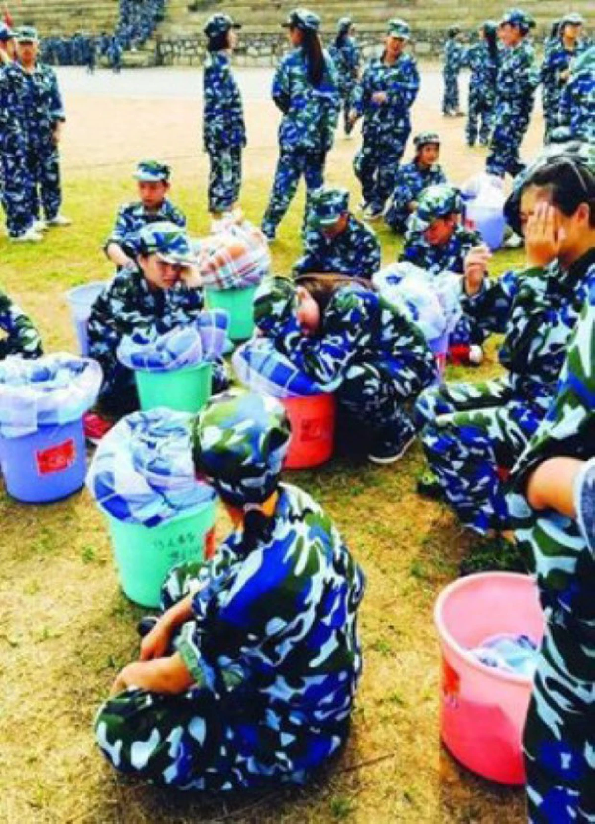 ดราม่า!ทหารจีนสั่งนศ.หญิงนอนห่มผ้ากลางแดดบนพื้นยางมะตอย เหตุห้องพักไม่เรียบร้อย