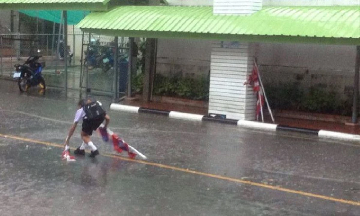 ชื่นชม!เด็กฝ่าสายฝนเก็บเสาธงชาติที่หักร่วงลงบนถนนจากลมพัด