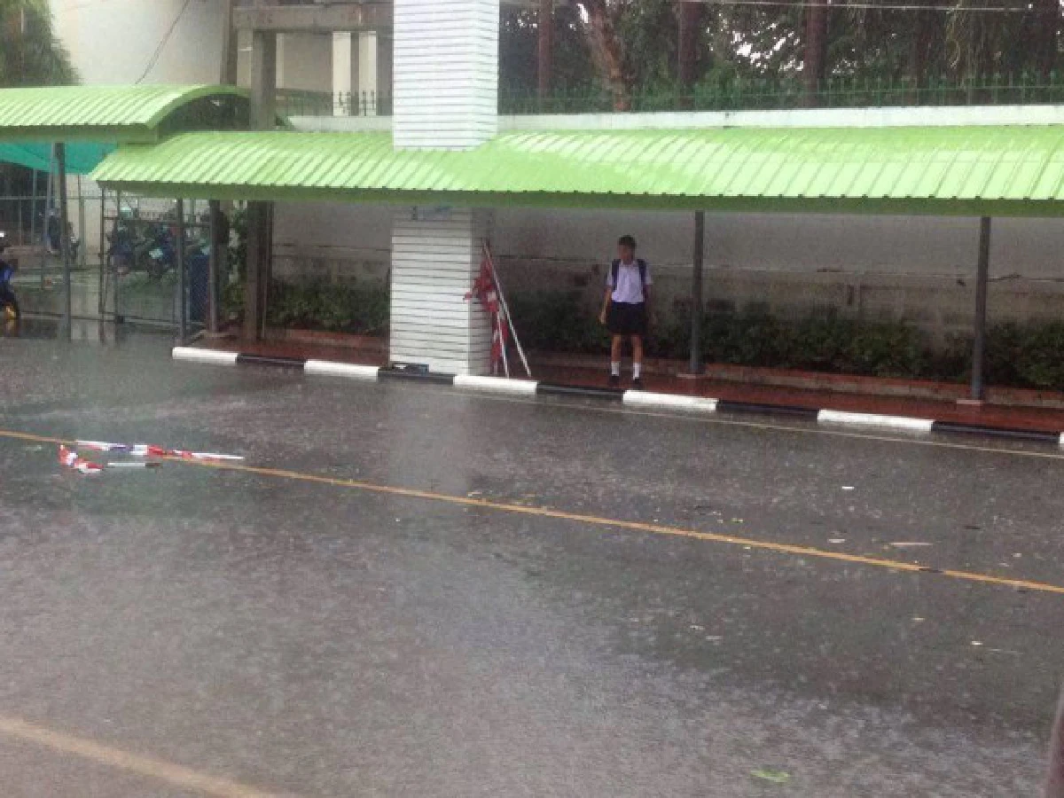 ชื่นชม!เด็กฝ่าสายฝนเก็บเสาธงชาติที่หักร่วงลงบนถนนจากลมพัด