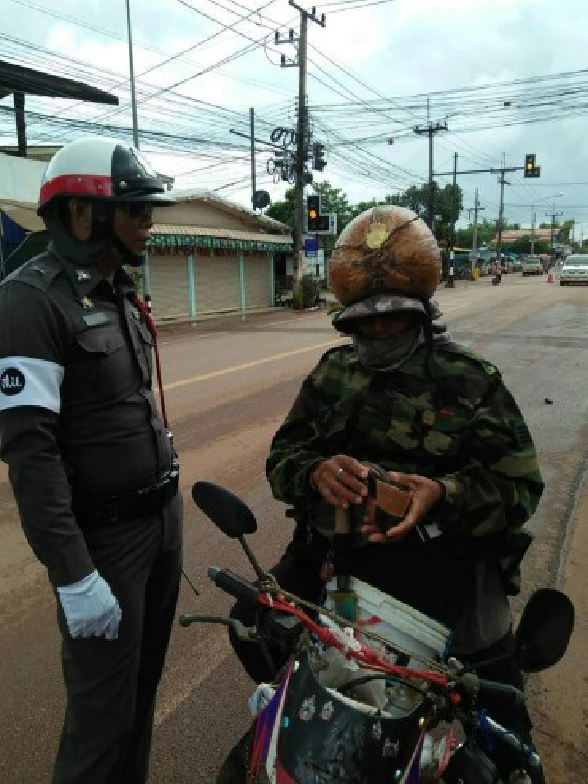 ตำรวจเรียกปรับ ชายใส่แจ็คเก็ตทหาร ใช้มะพร้าวเป็นหมวกกันน็อค