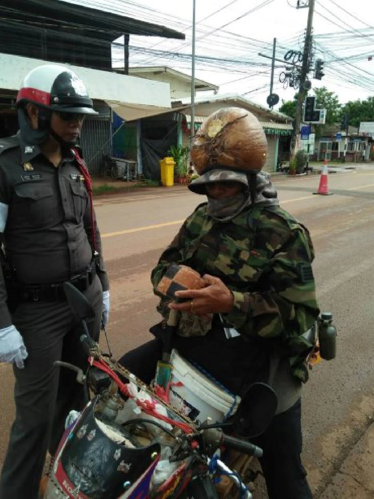 ตำรวจเรียกปรับ ชายใส่แจ็คเก็ตทหาร ใช้มะพร้าวเป็นหมวกกันน็อค