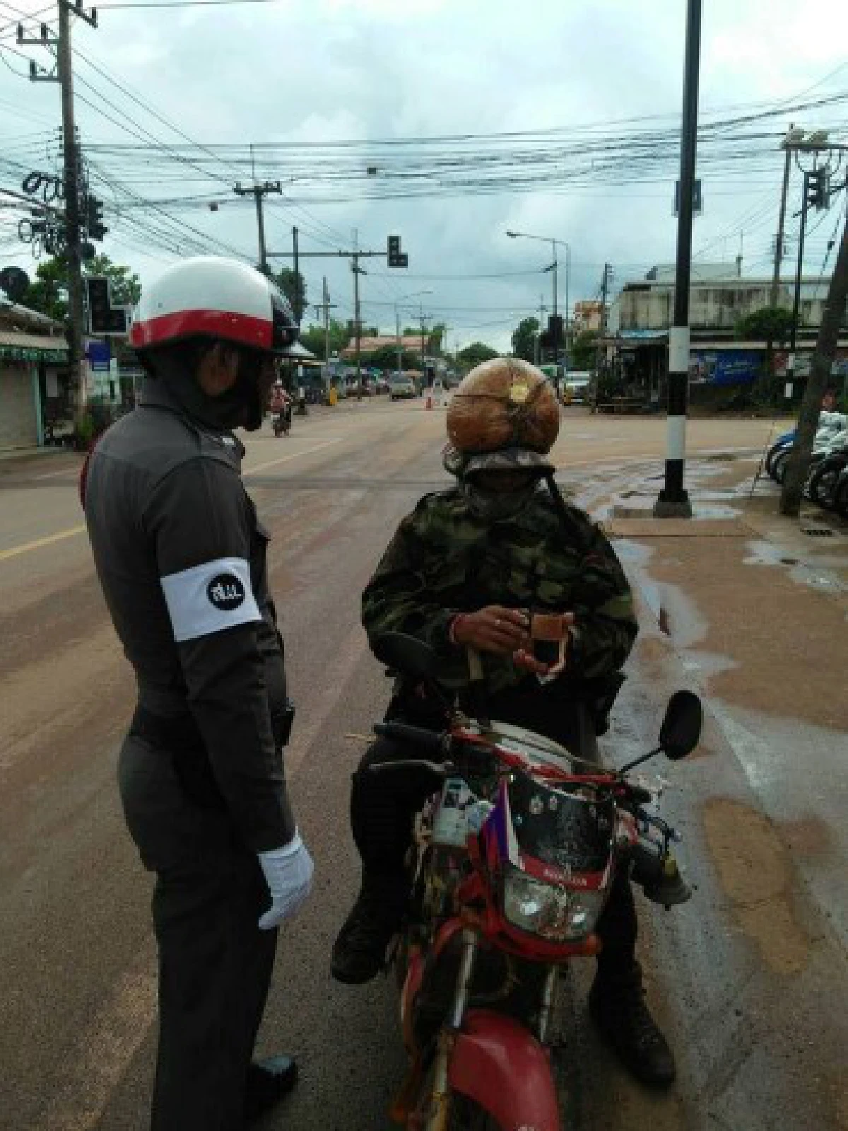 ตำรวจเรียกปรับ ชายใส่แจ็คเก็ตทหาร ใช้มะพร้าวเป็นหมวกกันน็อค