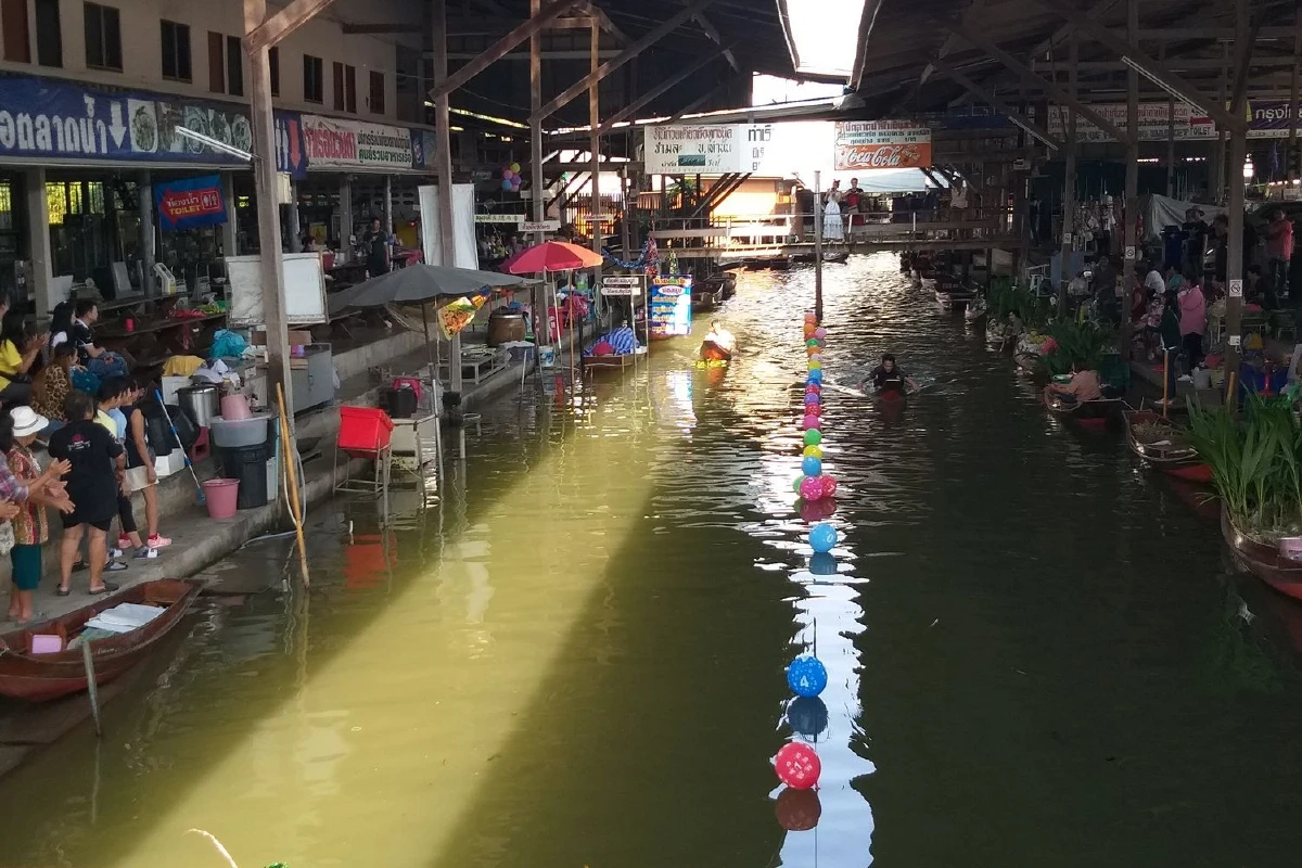 ผู้ค้าตลาดน้ำดำเนินสะดวกฉลองปีใหม่แข่งพายเรือด้วยมือ