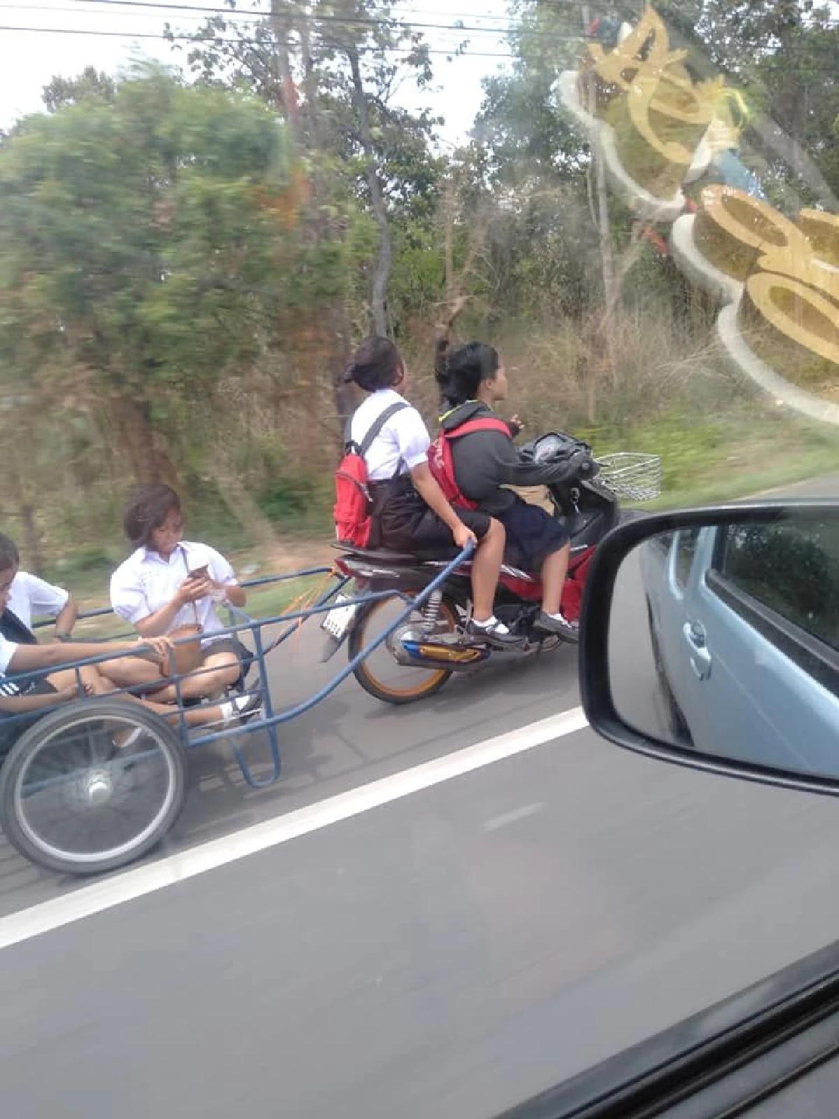 ได้ใจ! นร.สาวควบมอเตอร์ไซค์พ่วงรถเข็นให้เพื่อนนั่งยกแก๊งไปรร.