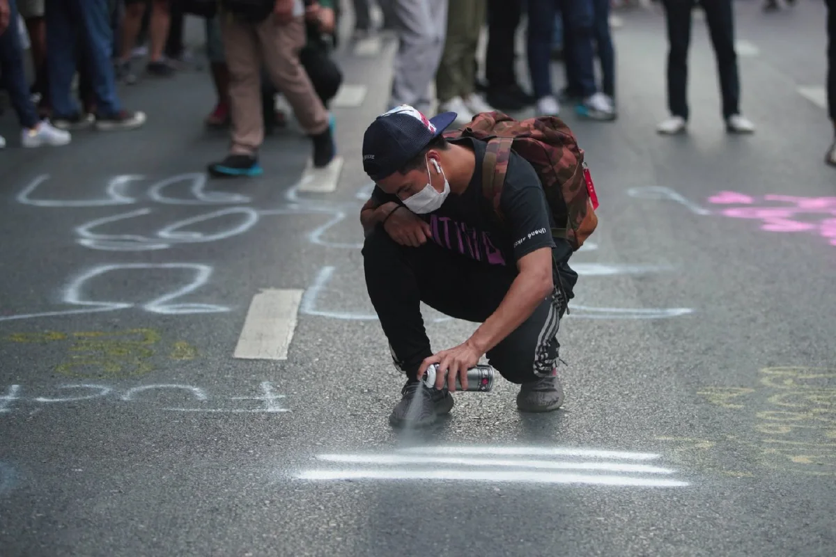 ม็อบเริ่มทำกิจกรรมใช้สีพ่นข้อความบนถนนหน้าสตช. "รุ้ง"ยืนยันไม่มีการบุกเข้าไป