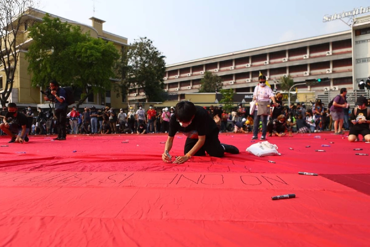 ราษฎรมาตามนัดขึงผ้าแดงอนุสาวรีย์ปชต.ชวนเขียนข้อความยกเลิกม.112