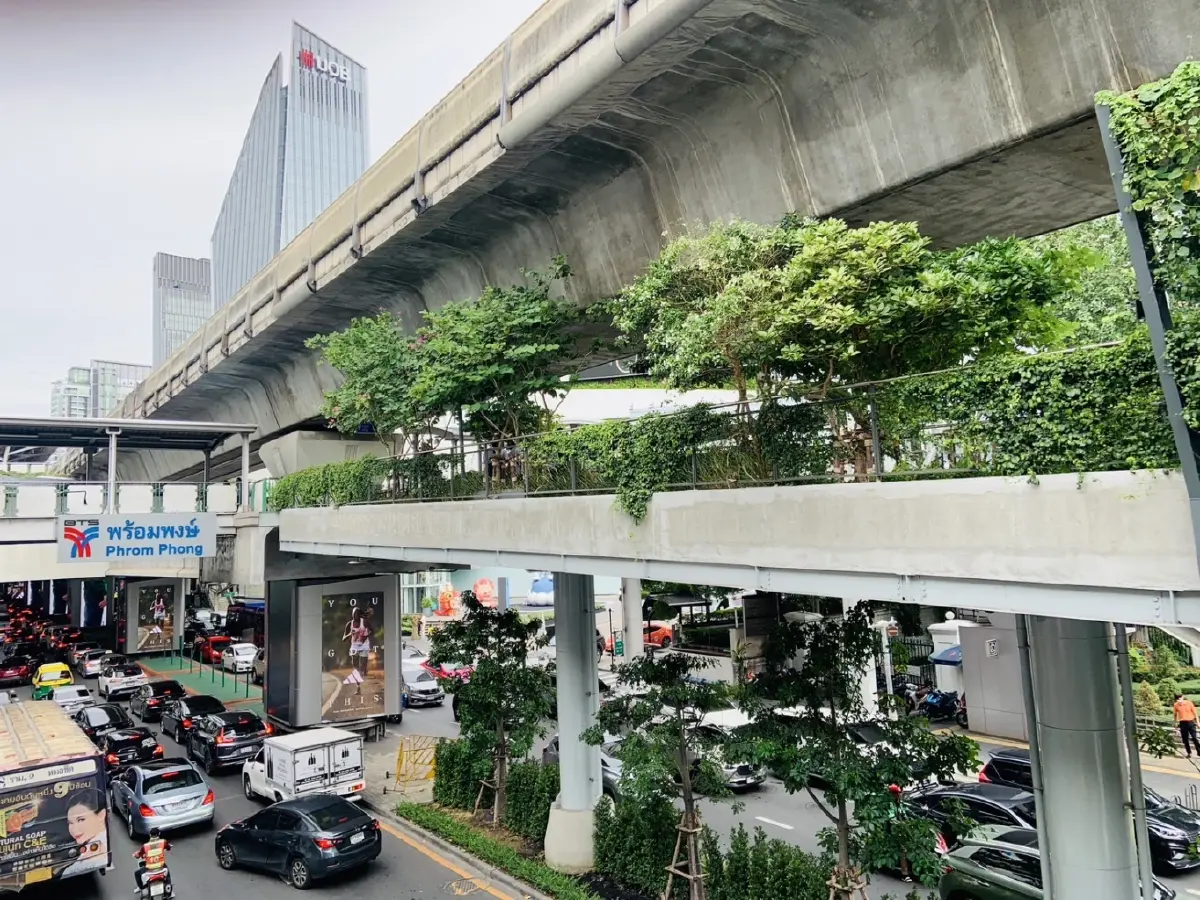 การจราจรที่แออัดด้านล่างสถานีบีทีเอสพร้อมพงษ์ ตัดกับความเขียวขจีของพื้นที่ด้านบน